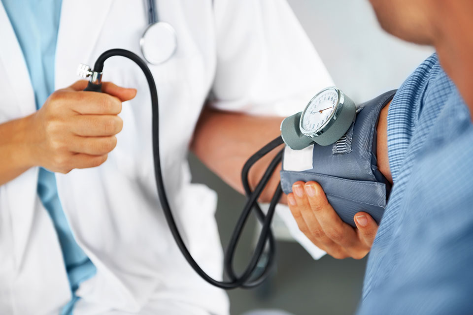 Doctor measures patient's blood pressure.