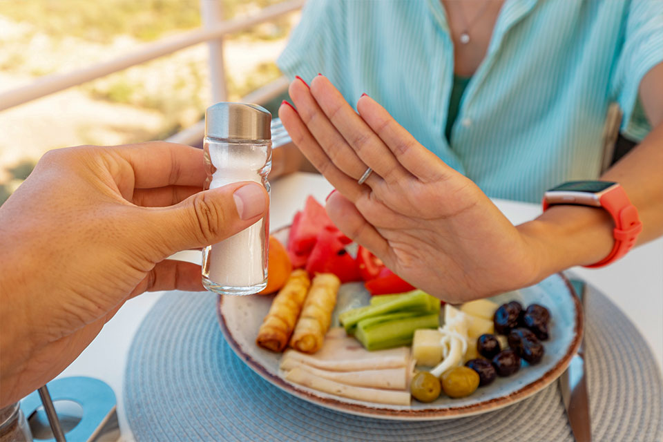 Woman gestures "no" to salt