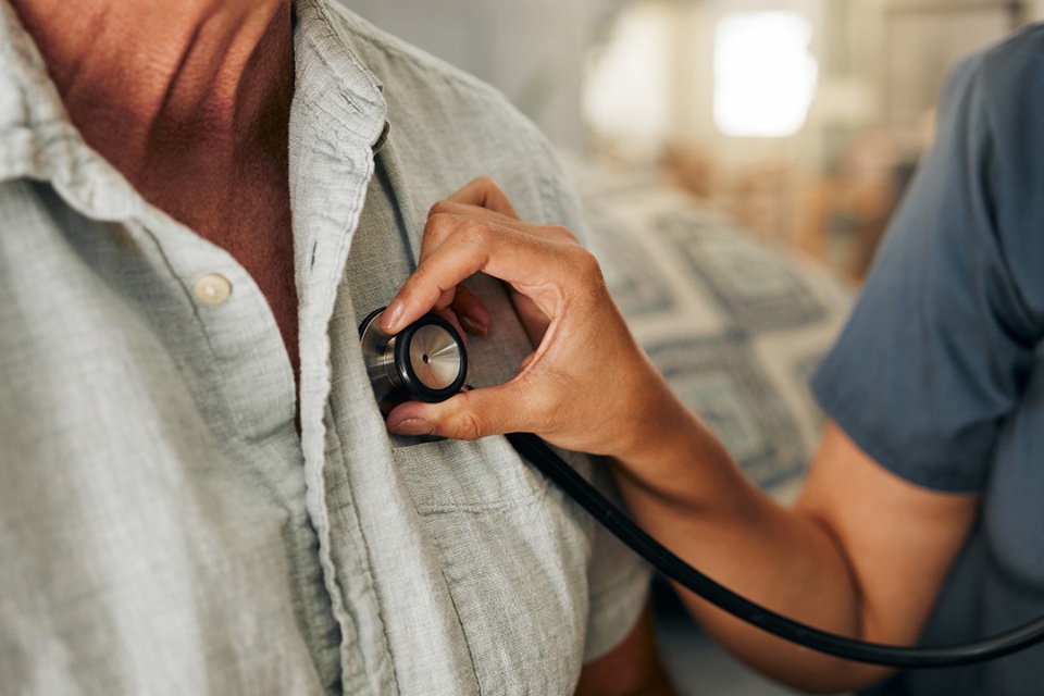 Nurse listens to patient's heart.